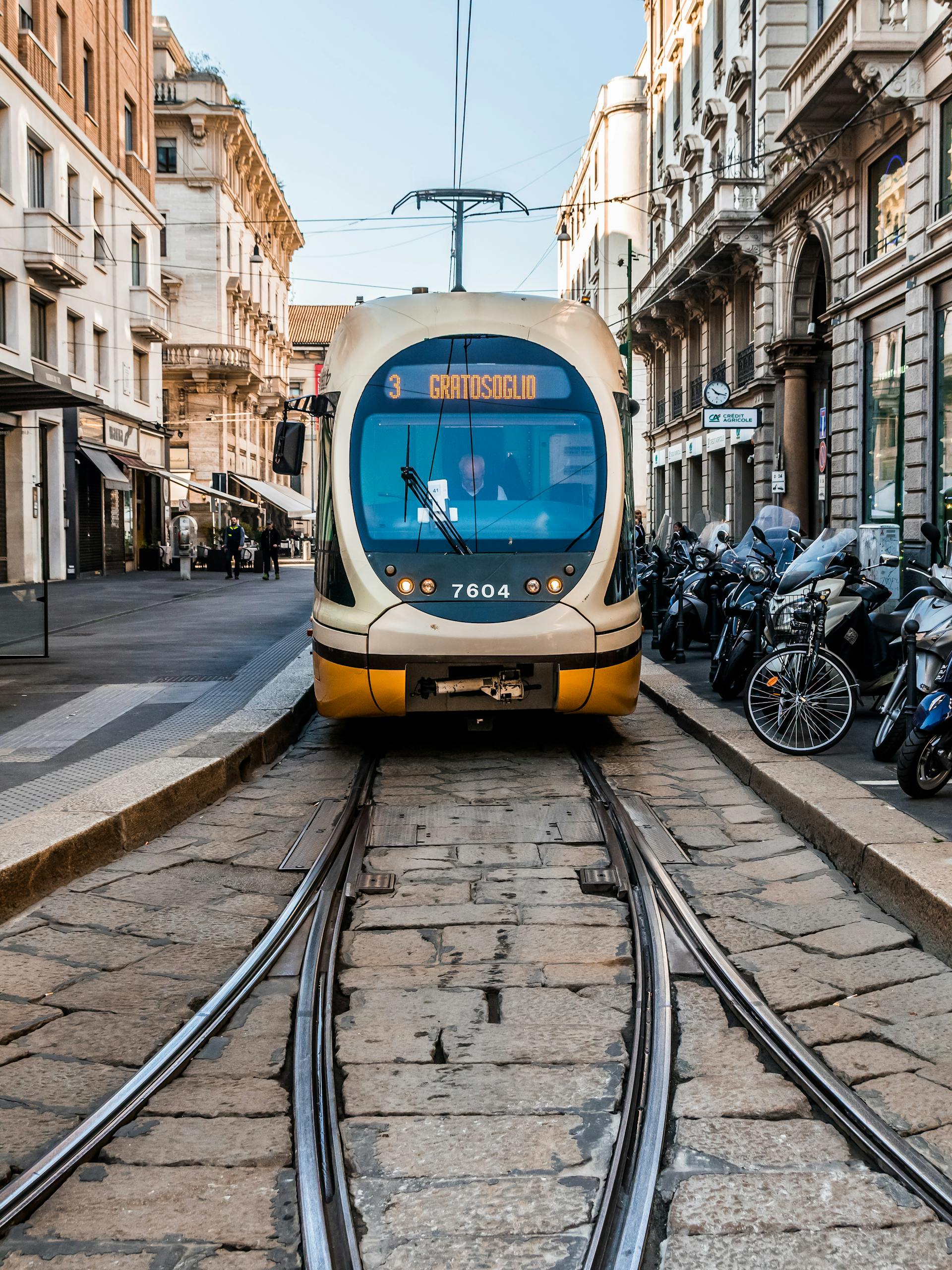Capture of a tram navigating urban streets flanked by iconic European architecture.